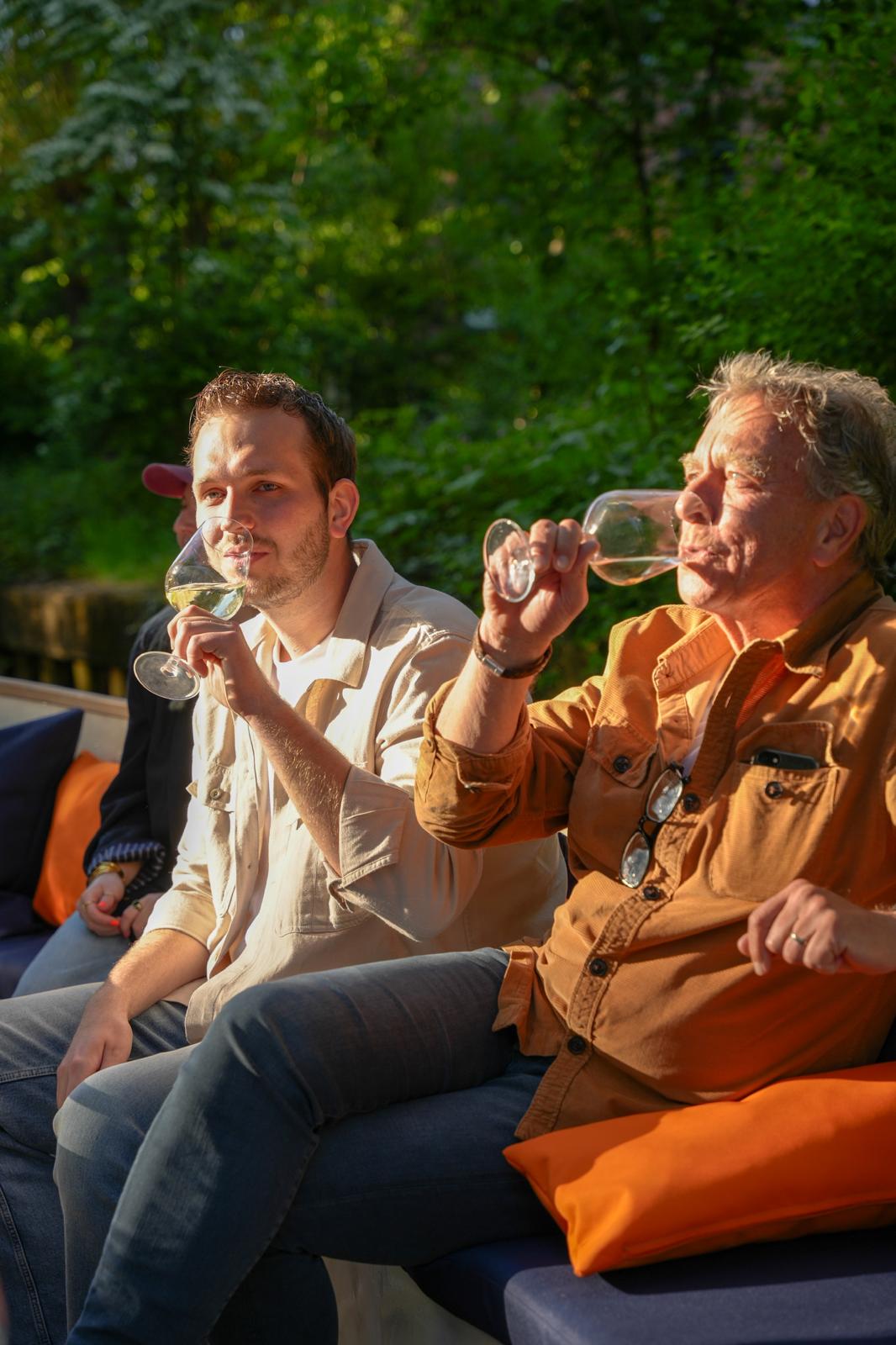 Bootje varen in Breda met Ervaar Breda op een rondvaartboot over de singels van Breda, waar gasten gezellig aan het drinken zijn aan boord.